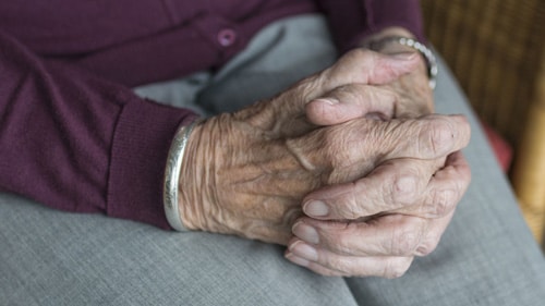 aging parent hands closed on her lap