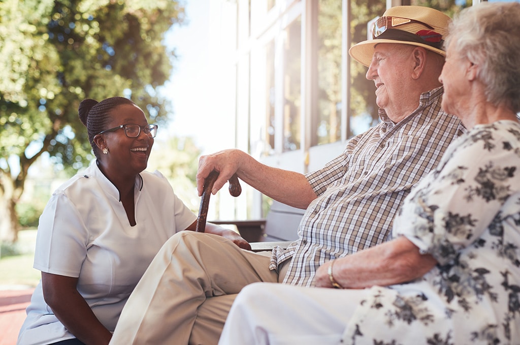 Caregiver laughing with senior couple
