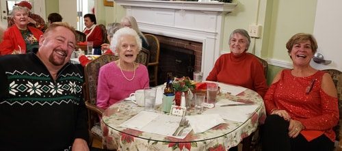 group of smiling people surrounding a table